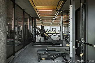 [Translate to Français:] Different fitness equipment in a gym with dark-coloured REGUPOL flooring