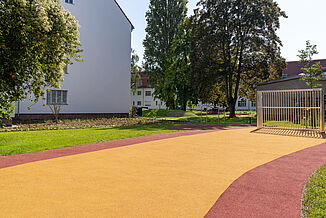 Aire de jeux et de loisirs accessible à Berlin-Steglitz-Zehlendorf, équipée d'un revêtement de sécurité amortissant les chocs REGUPOL playfix fun et d'un revêtement sportif REGUPOL multicourt DLX.