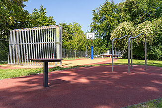 Espace sportif et ludique inclusif à Berlin-Steglitz-Zehlendorf, équipé d'un revêtement de sécurité amortissant les chocs REGUPOL, d'un revêtement sportif, d'un terrain de basket et d'équipements de gymnastique au sol.