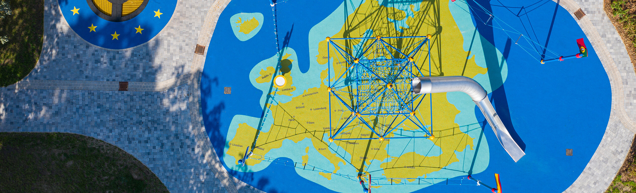 Aire de jeux avec un revêtement de sécurité en forme de carte du monde de REGUPOL