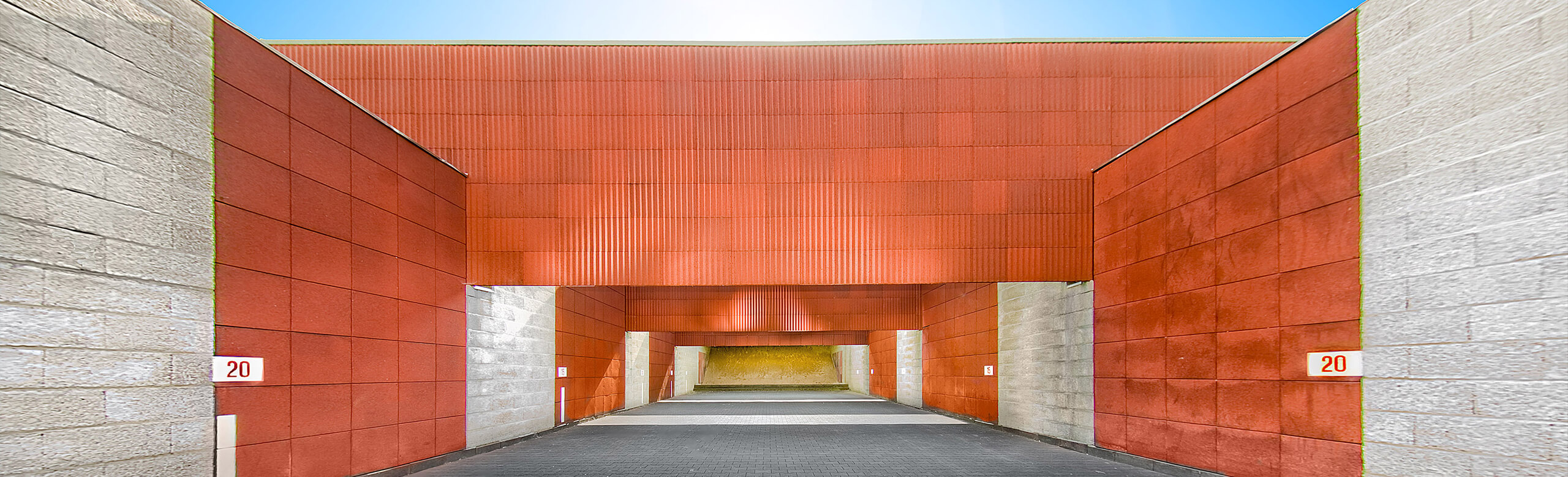 Installation de tir en extérieur avec différents produits REGUPOL. Des plaques élastiques rouges sont installées sur les écrans hauts.