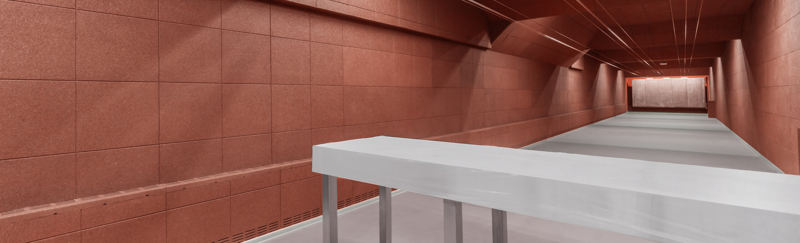 Un mur dans un stand de tir est équipé de plaques élastiques rouges REGUPOL.