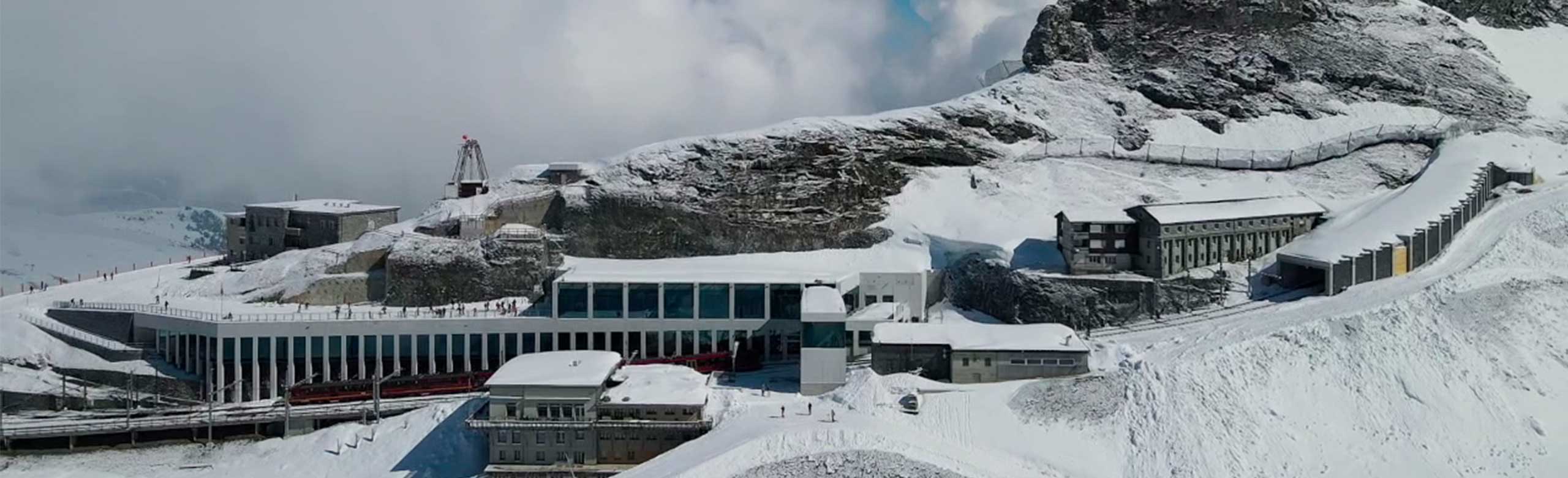 Vue extérieure d'une station supérieure d'un chemin de fer de montagne. Vue extérieure d'une station supérieure d'un chemin de fer de montagne. La station supérieure se trouve sur une montagne. La montagne et la station amont sont recouvertes de neige.